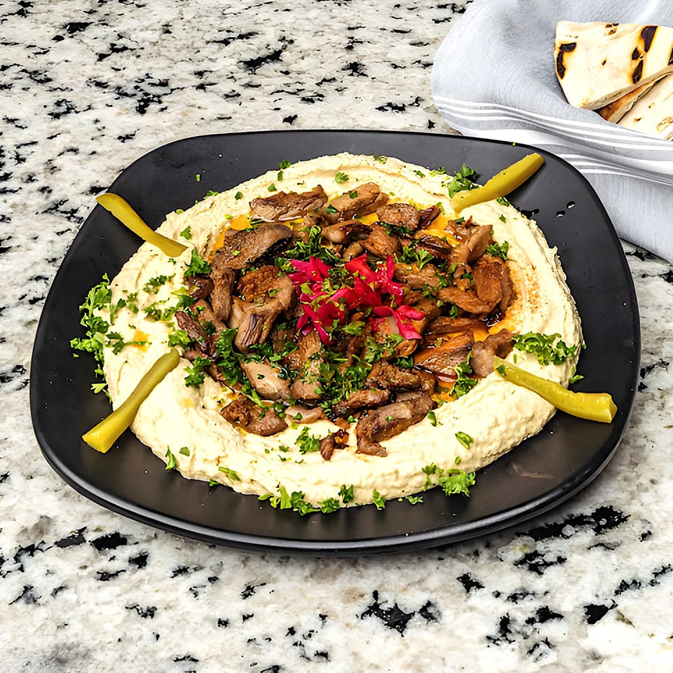 Hummus topped with seasoned meat, red pickled onions, parsley, and green peppers, served with pita.
